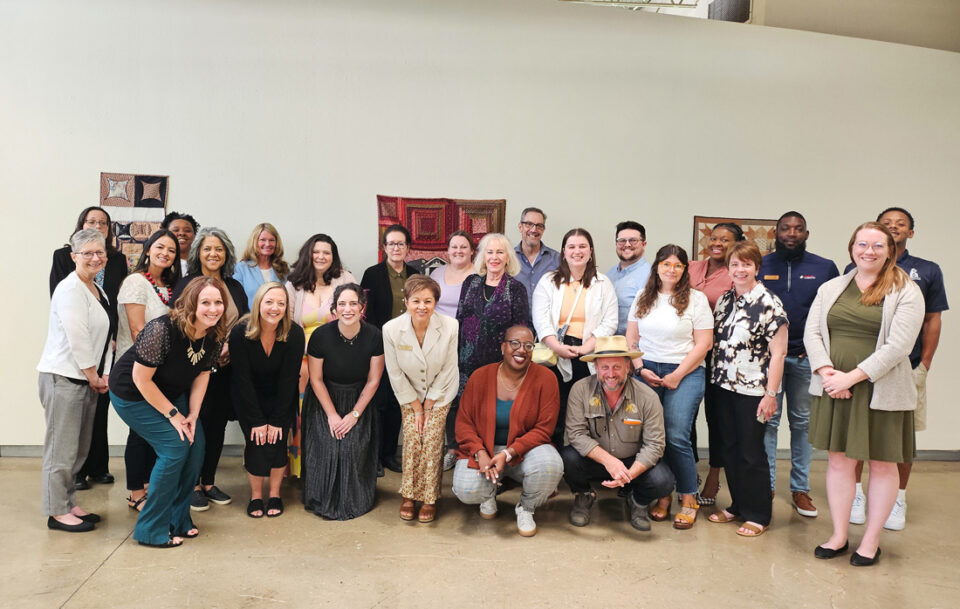 Group of people of various ages and ethnicities standing together for a portrait.