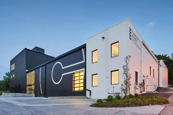 Modern industrial black and white building with a large "C" on the side for Charlotte Street.