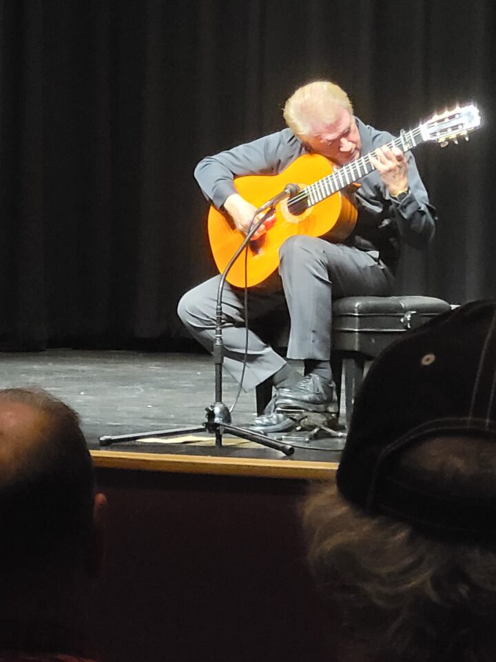 Man playing guitar on a stage.