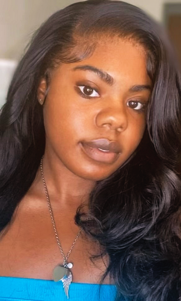 A portrait headshot of a college-aged African American woman wearing a blue shirt.