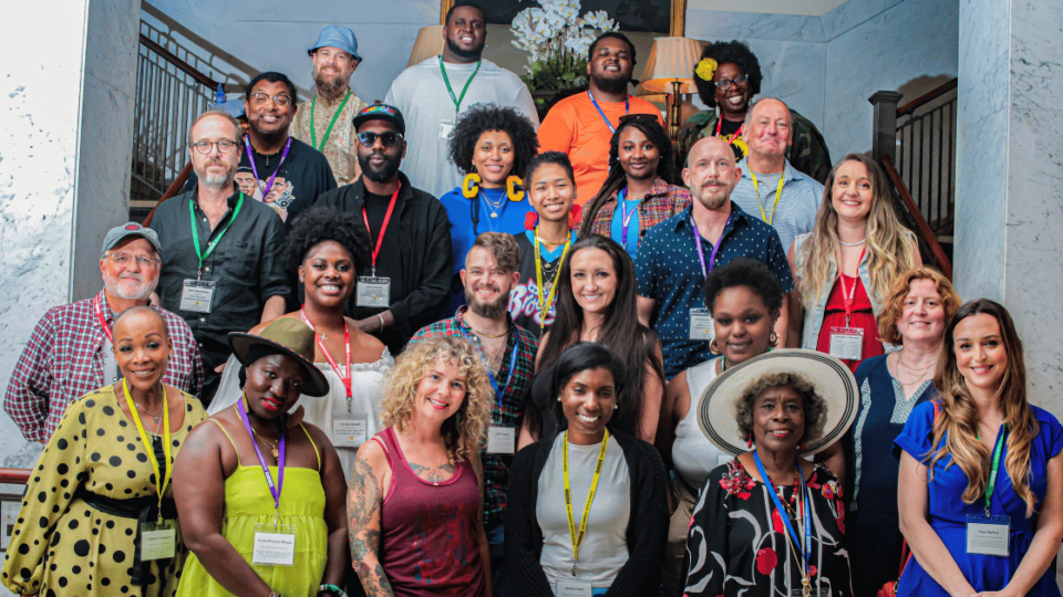 A large group of artists and creatives standing together for a group photo.