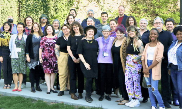 A large group of people stand together for a group photo.