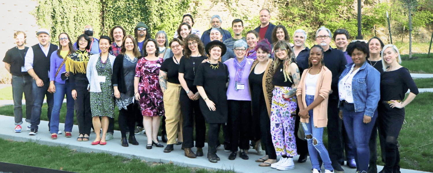 A large group of people stand together for a group photo.