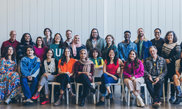 Large group of artists and creatives stand together for a portrait photo.