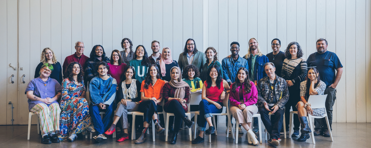 Large group of artists and creatives stand together for a portrait photo.